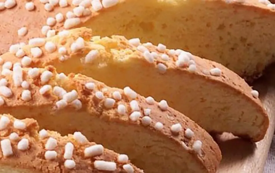La Ciambella Romagnola, conosciuta anche come "brazadela", è uno dei dolci più tradizionali della cucina riminese e romagnola. Questo biscotto dalla consistenza fragrante e dal gusto genuino è preparato con farina, uova, burro e zucchero, ed è caratterizzato dalla presenza di granella di zucchero sulla superficie, che gli dona un tocco croccante irresistibile. Perfetta da gustare a colazione, a fine pasto o da inzuppare in un bicchiere di Albana dolce, è un simbolo della pasticceria casalinga della Romagna.