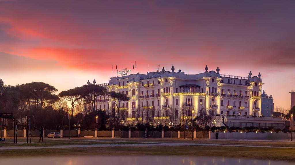 Facciata illuminata del Grand Hotel di Rimini al tramonto, vista da Piazzale Fellini